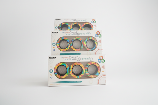 Three packages of a colorful ring product on a wooden surface with a blurred background.