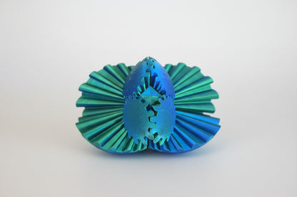 Green and blue plastic fidget spinner with geometric design on a wooden surface