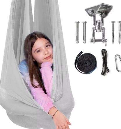 Child in a gray swing with hanging equipment on a white background