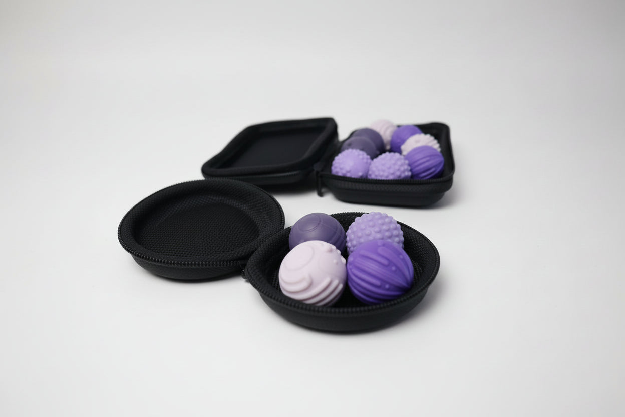 Set of purple and pink textured fidget balls in a black case on a white surface